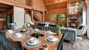 Een blokhut interieur met een eethoek, open haard en stenen details.