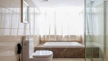 A modern bathroom with a toilet, a sink, a bathtub, and a glass shower enclosure.