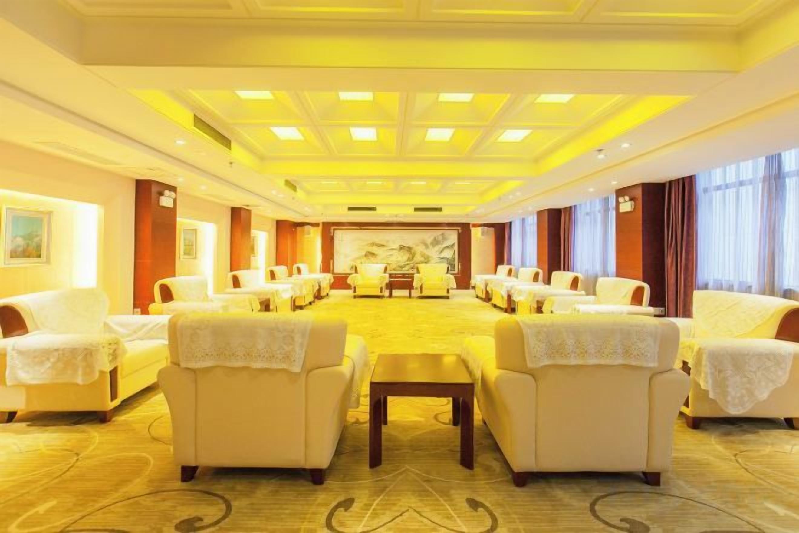 A conference room with a long table and multiple chairs, carpeted floor, and a large painting on the wall.