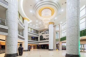 A spacious atrium with marble columns, a central chandelier, and multiple levels. - Dabieshan Hotel (Luotian County)