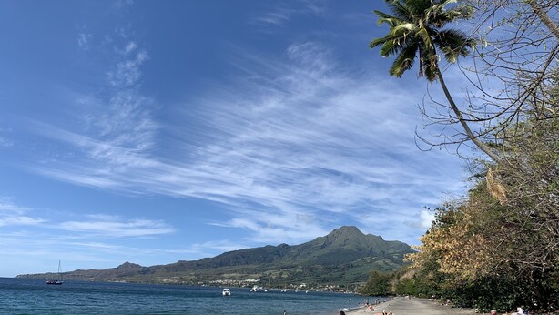 A beach with clear skies, calm waters, and a mountain in the background. - Magnificent villa with free parking ideally located. (Schoelcher)