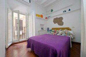 Une chambre à coucher avec un lit, une fenêtre donnant sur un beau paysage, un radiateur et une étagère remplie de livres.