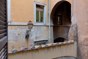 A building with a weathered facade, a small window with a shutter, and a visible number '1756' on the wall.