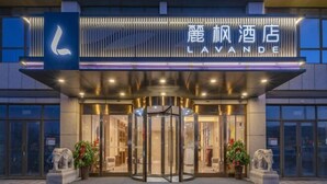 A hotel entrance with a revolving door, a prominent 'LAVANDE' sign, and two elephant statues on either side. - Lavande Hotel (Heze Daxue Road Branch) (Heze)