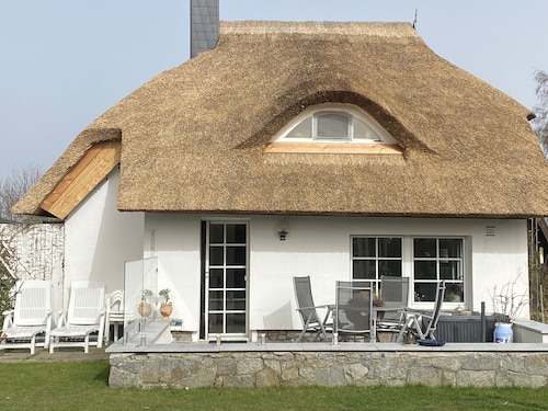Thatched-roof holiday home with water view, garden and fireplace 