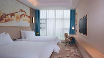 A hotel room with two beds, a desk with a chair, a TV, and a large window with curtains.