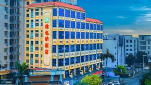 Un hôtel à plusieurs étages, reconnaissable à son enseigne bien visible indiquant qu’il s’agit d’un hôtel.
