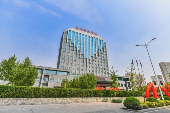 Contemporary building with a clean design, featuring a landscaped area and paved walkway.