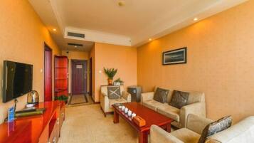 Una sala de estar con sofá, mesa de centro, televisor y un mueble rojo.