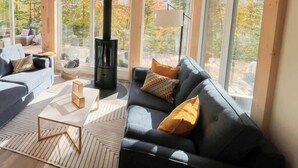 Un salon confortable avec une grande fenêtre, une cheminée et un canapé.
