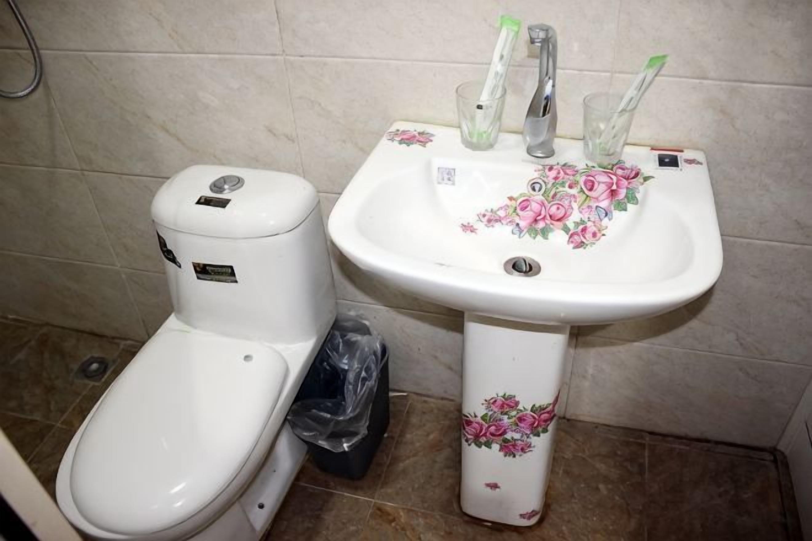 Ein Badezimmer mit Toilette, Waschbecken und Mülleimer.