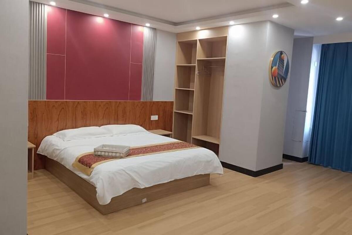 A bedroom with a wooden bed, a built-in wardrobe, and a large closet.