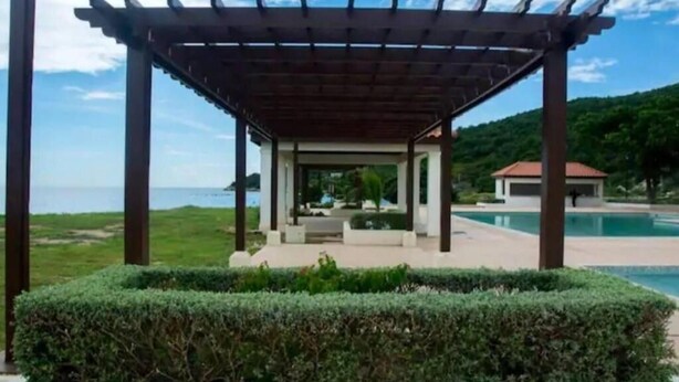A covered outdoor area with a pool and a view of the sea. - AC, WiFi, cable & 24/7 security, Pool, beachfront, views of Kingston harbor. (Portmore)