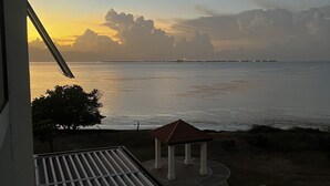A balcony with a view of the sea and a gazebo. - AC, WiFi, cable & 24/7 security, Pool, beachfront, views of Kingston harbor. (Portmore)