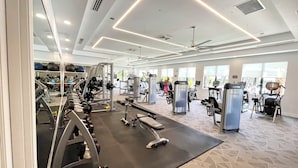 A gym with various exercise equipment, including treadmills, weight machines, and free weights.