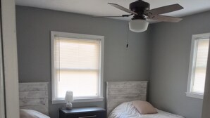 A bedroom with two beds, a ceiling fan, and a nightstand. - short walk to Ball State University Campus - Quiet Neighborhood (Muncie)