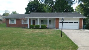 A single-story house with a front porch, a garage, and a well-maintained lawn. - short walk to Ball State University Campus - Quiet Neighborhood (Muncie)