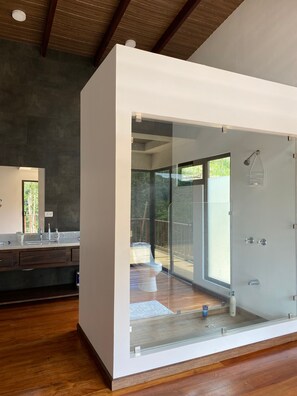 Un baño moderno con cabina de vidrio, ducha y retrete.