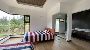 Un dormitorio moderno con dos camas, un ventanal y vistas al verdor.
