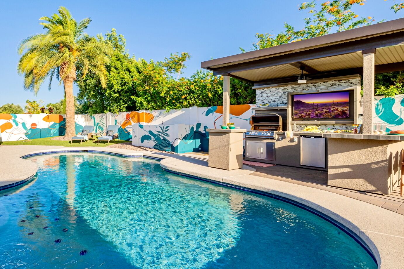 Resort-style backyard with heated pool, hot tub and outdoor kitchen and bar.