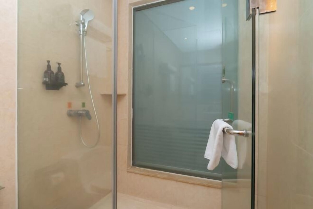Een douchecabine met glazen wanden, een handdoekhouder en toiletartikelen.