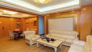 Un salón amplio con un gran sofá beige, una mesa de centro y un comedor con mesa y sillas.