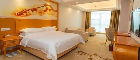 A hotel room with a large bed, a desk, a chair, a TV, and a decorative wall mural.