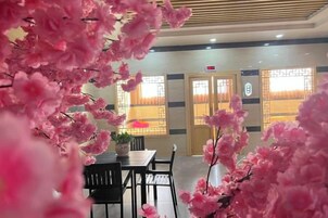 A hotel lobby with a reception desk, seating area, and a door with a sign.