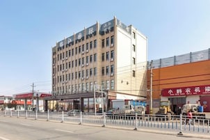 A multi-story hotel with a flat facade, a ground-level entrance, and a visible storefront on the right.