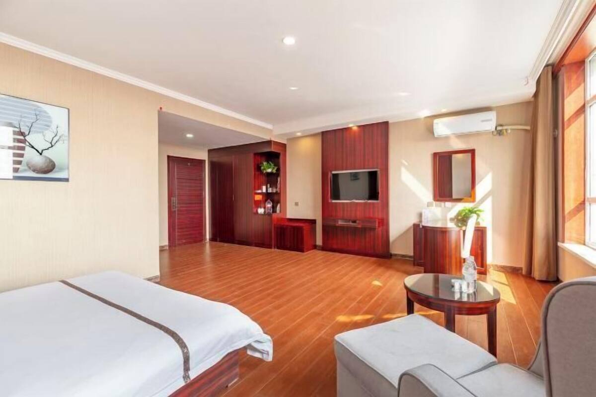 Een hotelkamer met twee bedden, een televisie, een bureau en een zithoekje.