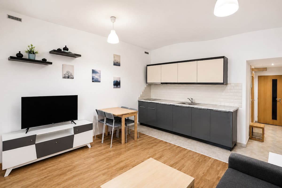 A modern kitchen with dark cabinets, a white countertop, and a built-in oven.