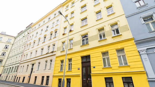 A row of multi-story buildings with a cobblestone street. - Ground Floor Apartment (Prague)
