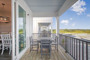 A covered outdoor dining area with a view of the beach.