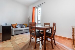 Ein gemütlicher Wohnbereich mit Esstisch, Stühlen, einer Couch und einem kleinen Beistelltisch.