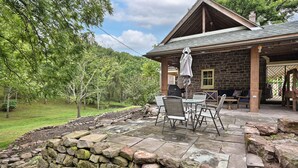 A stone patio with outdoor furniture, a covered seating area, and a stone wall. - A cozy, beautifully renovated 1829 farmhouse (Mechanicsburg)