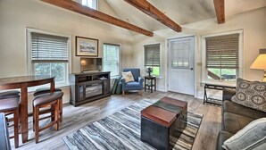 A spacious living room with a wooden ceiling, a dining area with a table and chairs, and a cozy seating area with a couch and armchairs. - A cozy, beautifully renovated 1829 farmhouse (Mechanicsburg)