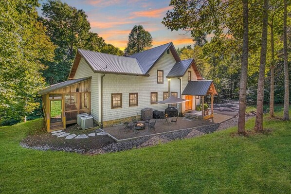 A house with a covered patio, outdoor seating, and a screened porch.