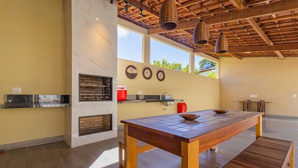 Une cuisine moderne avec une table en bois, un four encastré et une grande fenêtre.