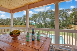 Enjoy a meal al fresco in this serene outdoor setting, complete with a beautifully set table and a refreshing pool view.