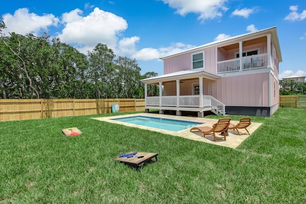 Enjoy a relaxing stay in this charming home with a front porch, balcony, and pool surrounded by a lush lawn.
