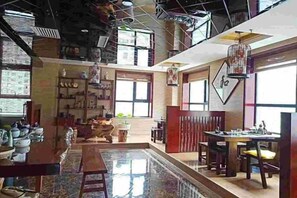 A spacious interior with a central open area, wooden furniture, and a variety of decorative items. - Zhenghe Holiday Hotel (Zhen'an)