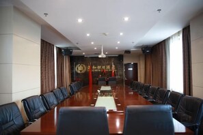 A conference room with a long table, chairs, and a banner on the wall. - Zhenghe Holiday Hotel (Zhen'an)