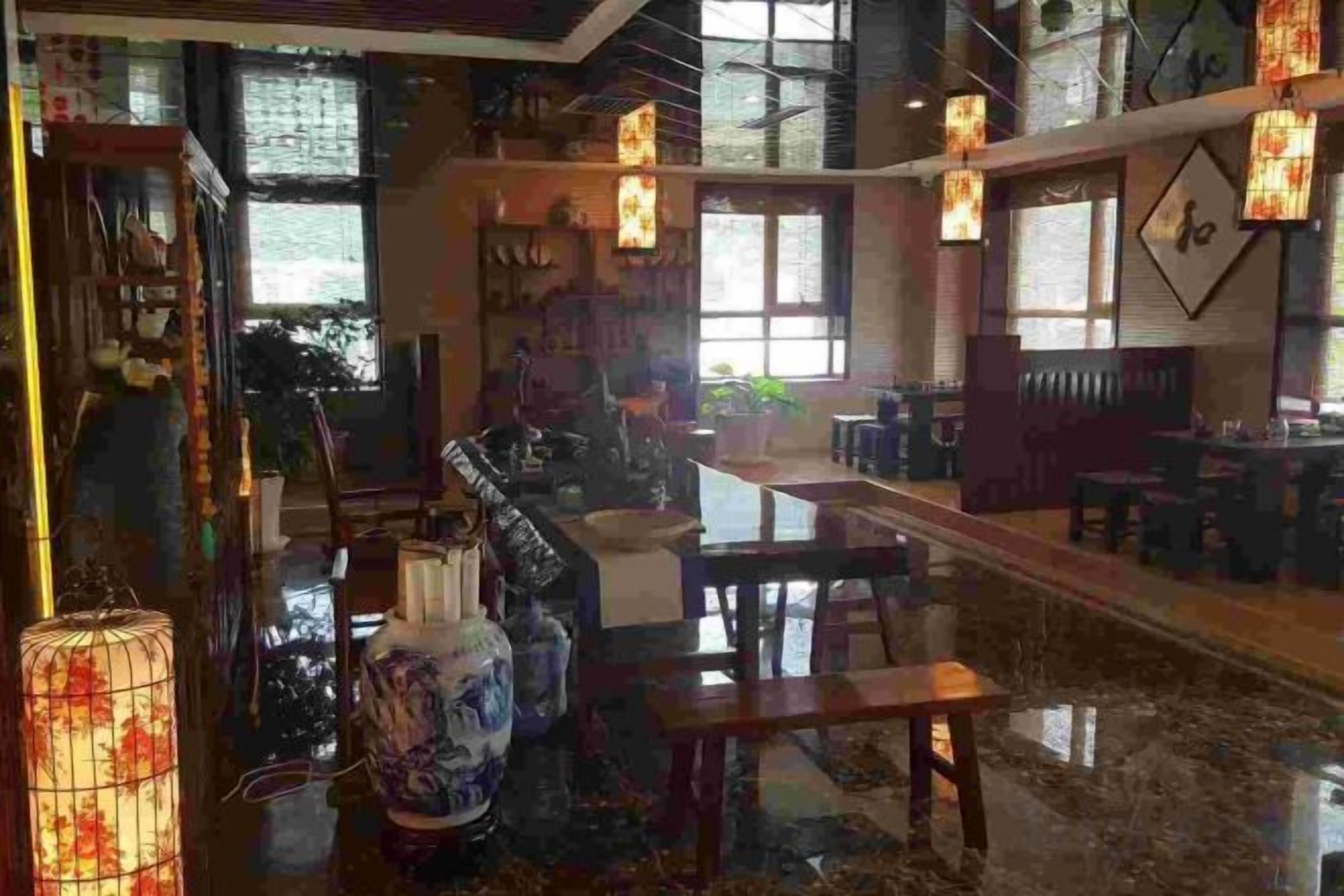 A spacious room with a dining area, a large window, and a decorative vase.