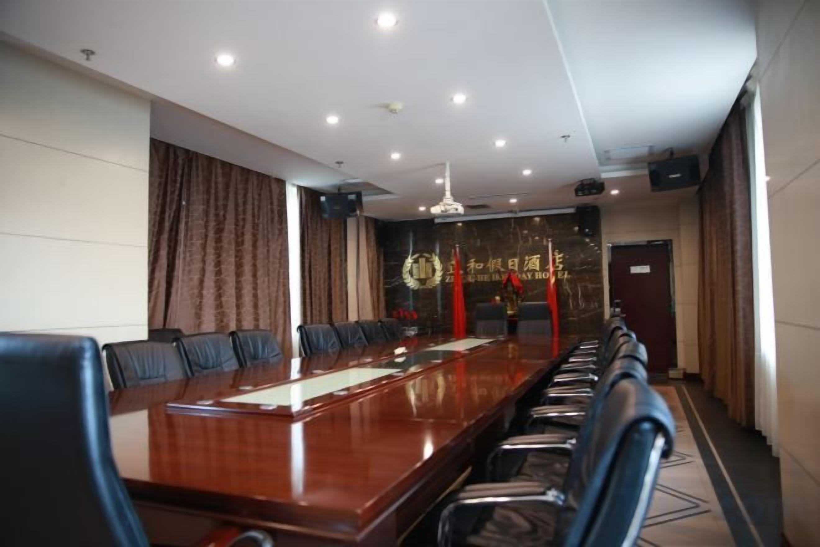 A conference room with a long table, chairs, and a chandelier.