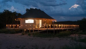 A circular building with a central open area, surrounded by a deck with railings and string lights.