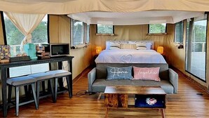 Un dormitorio acogedor con cama, lámparas de noche, un escritorio y un banco.