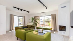 Una sala de estar moderna con sofás verdes, una mesa de centro y una chimenea.