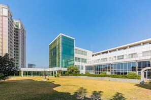 Un bâtiment moderne doté d’une cour intérieure, de grandes fenêtres et d’une combinaison de structures en verre et en béton.