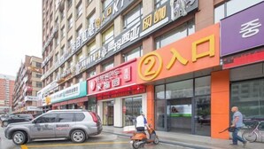 A street view with a building featuring a prominent '2' sign, suggesting a business or service location. - Apple Apartment (Yanji)