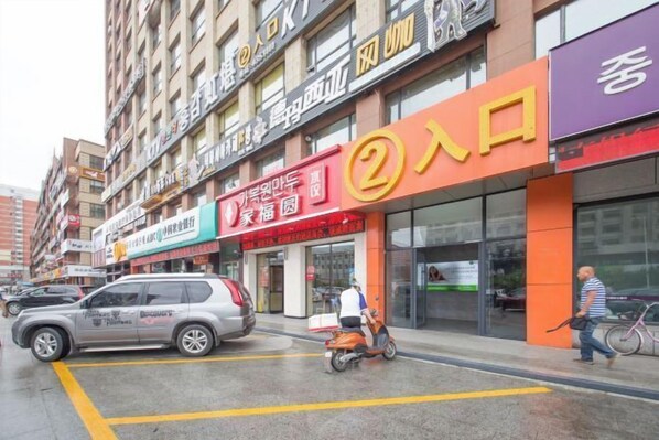 A street view with a building featuring a prominent '2' sign, suggesting a business or service location. - Apple Apartment (Yanji)